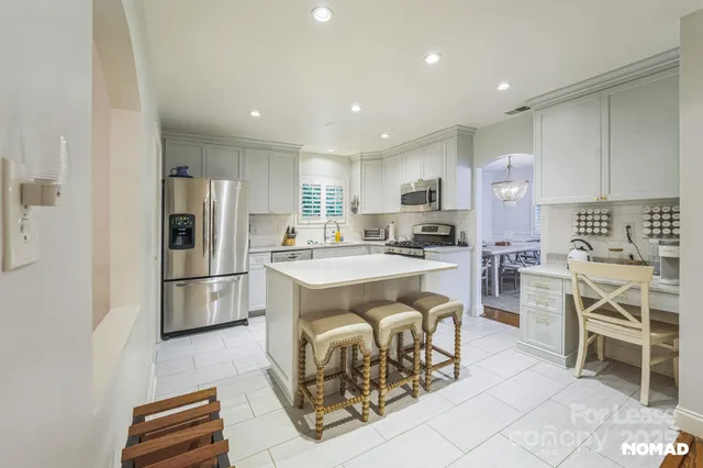 a kitchen with white cabinets and stainless steel appliances
