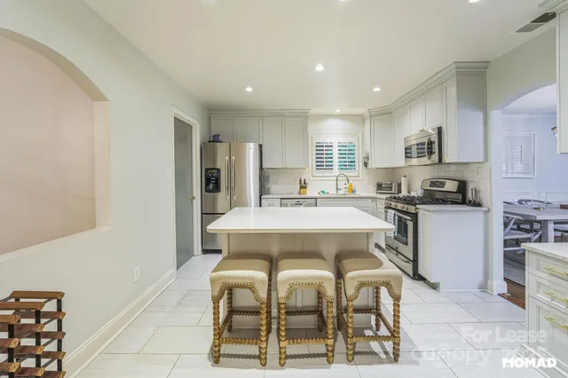 a large kitchen with a table and chairs