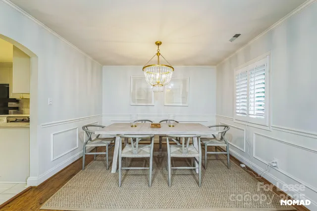 a dining room that has a dining table and a chandelier