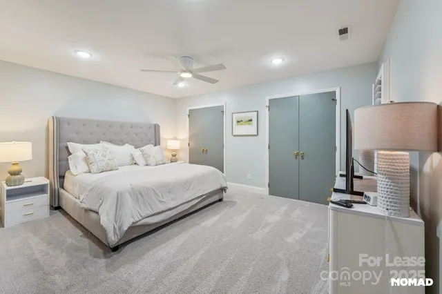 a large bedroom with a bed and a chandelier