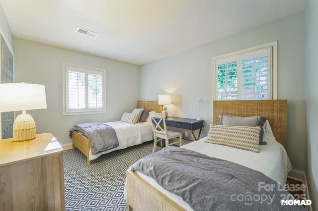 a bedroom with two beds and a night stand