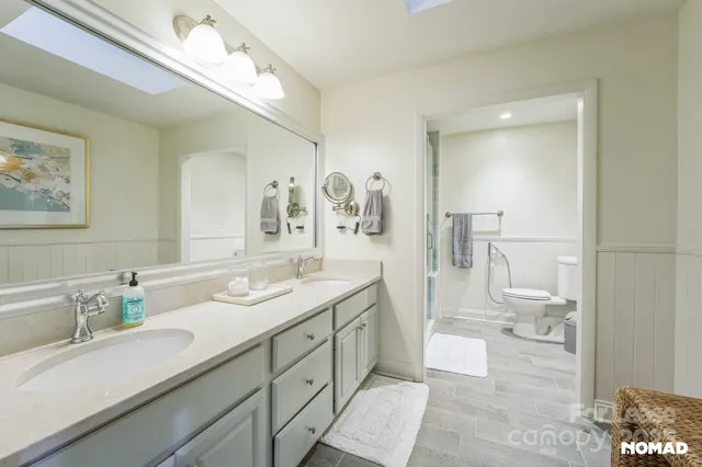 a spacious bathroom with a granite countertop sink mirror and a toilet