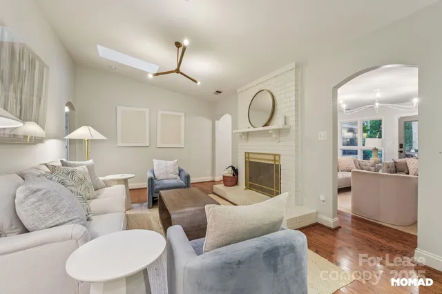 a living room with furniture a fireplace and a chandelier