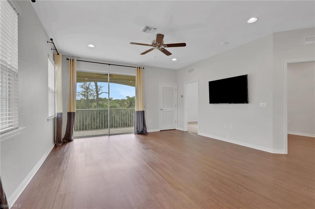 18320 Creekside Preserve Loop, Unit 201 Fort Myers, FL 33908 - Photo 11 of 27 Unfurnished living room with light wood-style flooring, a ceiling fan, and recessed lighting