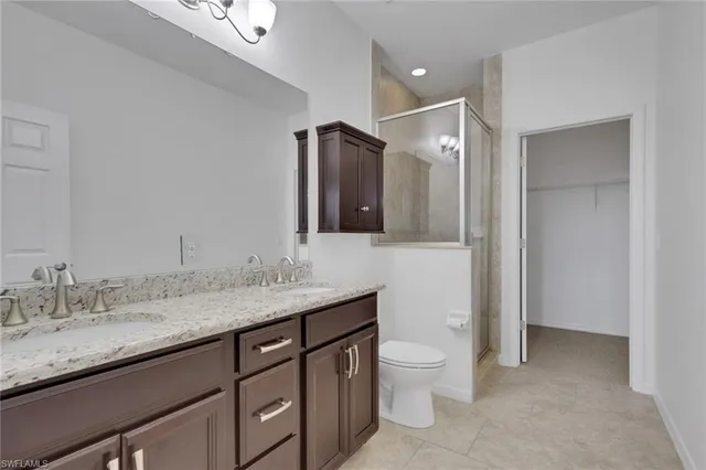 a bathroom with a granite countertop sink a toilet and a mirror