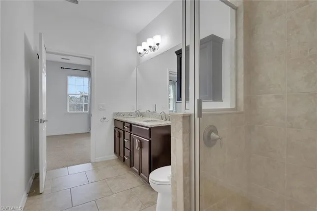 a bathroom with a granite countertop sink toilet and a mirror