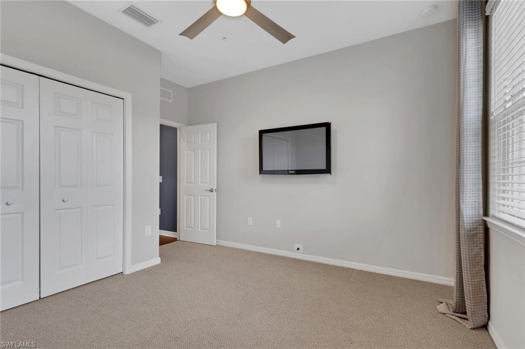 18320 Creekside Preserve Loop, Unit 201 Fort Myers, FL 33908 - Photo 22 of 27 Unfurnished bedroom with light carpet, a closet, and a ceiling fan