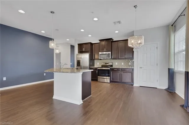 a kitchen with a refrigerator and a stove top oven