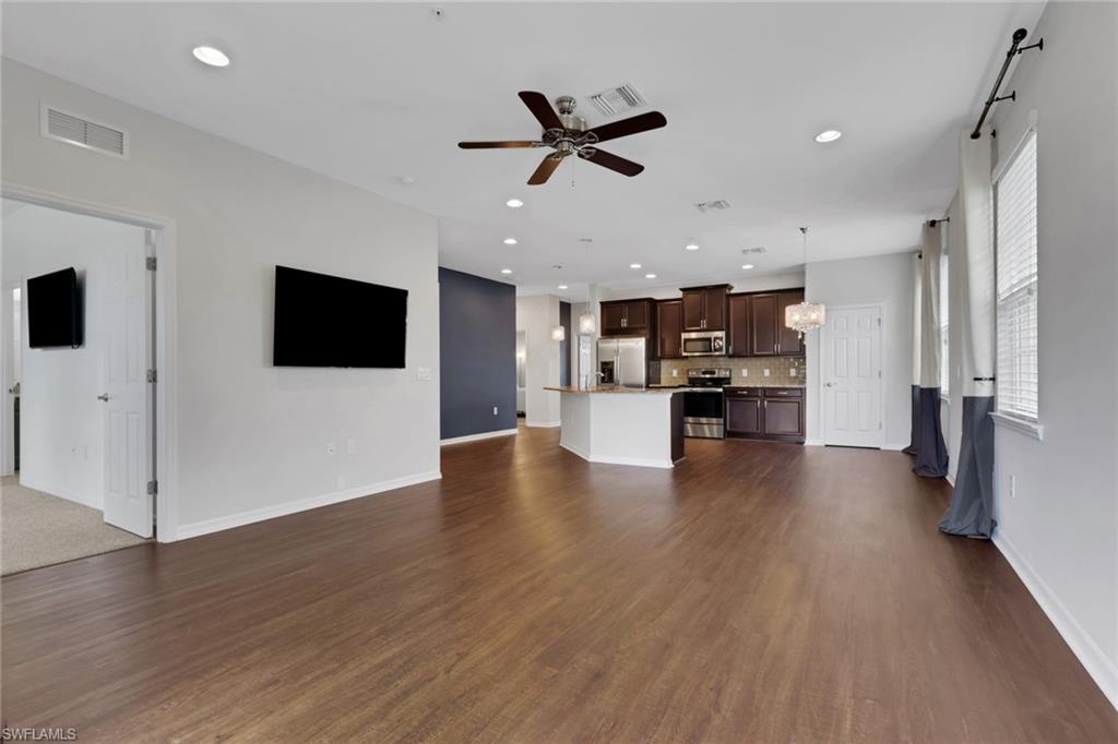 18320 Creekside Preserve Loop, Unit 201 Fort Myers, FL 33908 - Photo 9 of 27 Unfurnished living room featuring a ceiling fan, dark wood-style flooring, recessed lighting, and a chandelier