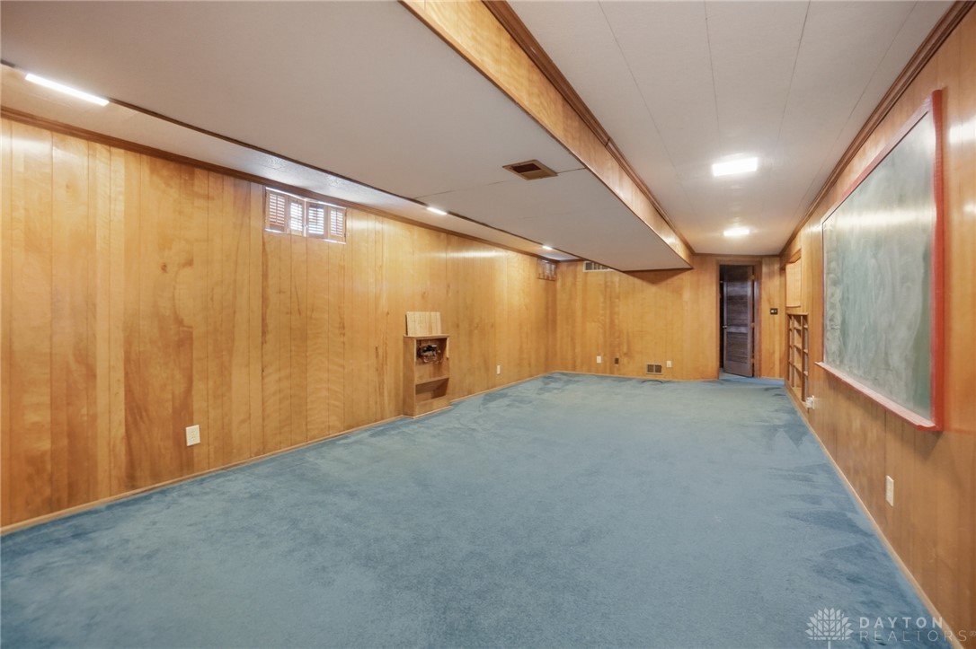 6119 Flemington Road Dayton, OH 45459 - Photo 41 of 76 This spacious area offers ample room for recreation or storage, featuring durable paneling and carpeting.