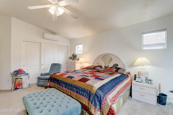 a bedroom with a bed a large window with table and chairs