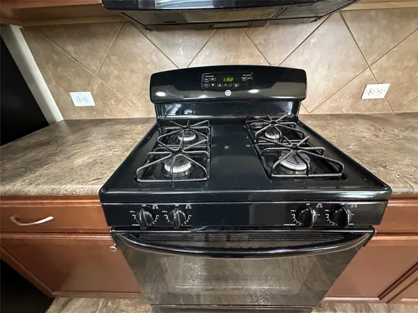 a stove top oven sitting inside of a kitchen