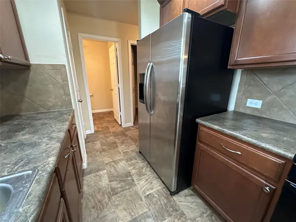 a view of a refrigerator a sink and a window