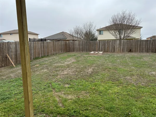 a view of a backyard with wooden fence