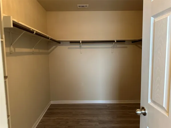 a view of walk in closet with empty racks