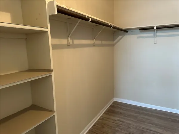 a view of walk in closet with empty racks