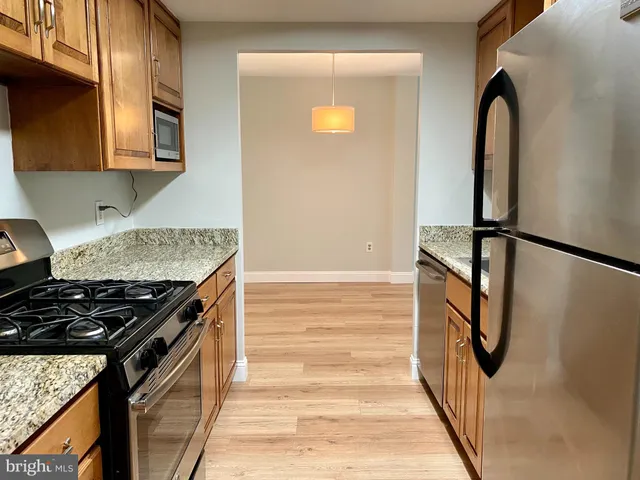a kitchen with granite countertop a stove and a refrigerator