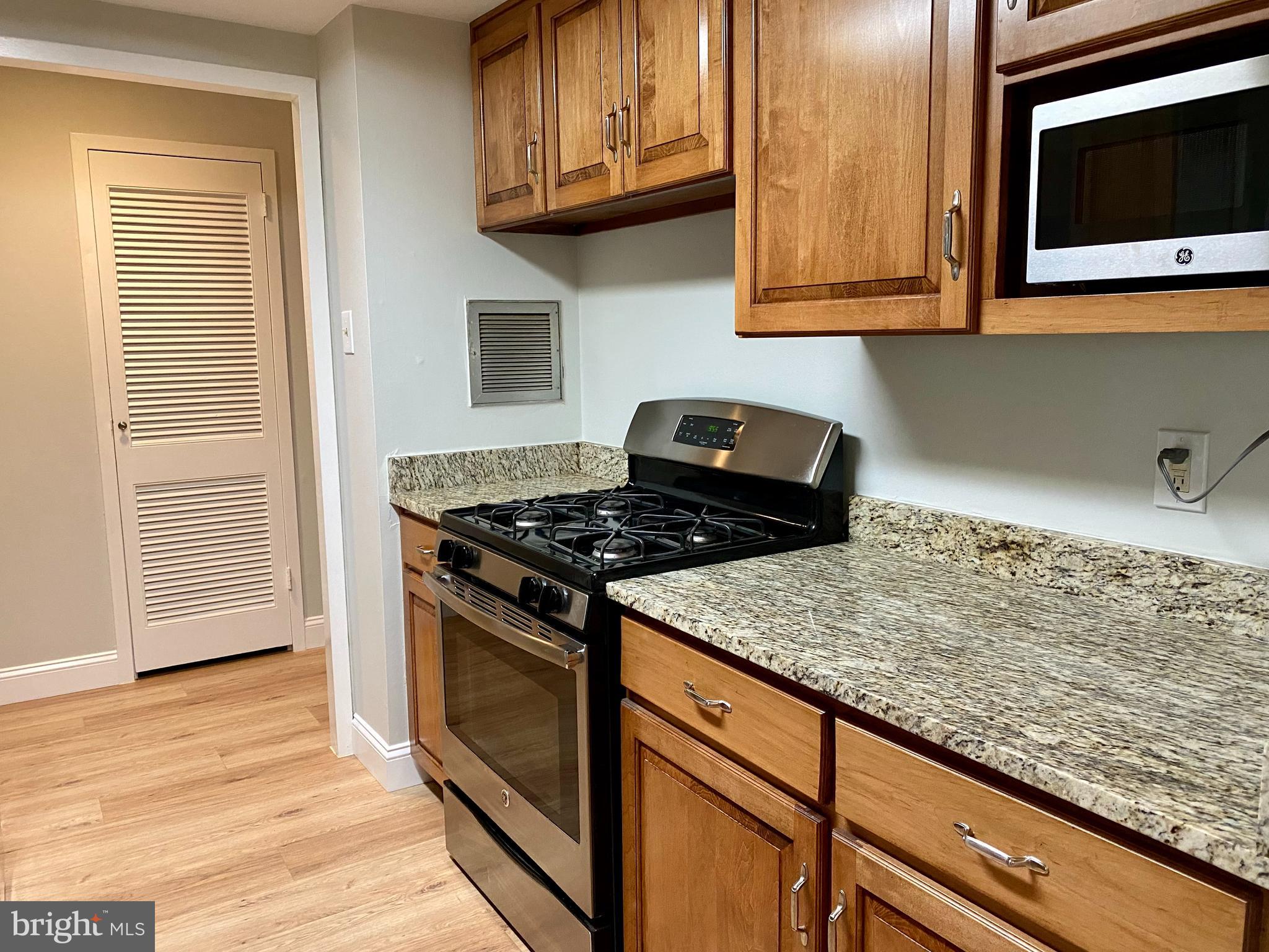 100 West Avenue, Unit 218S Jenkintown, PA 19046 - Photo 14 of 29 a kitchen with granite countertop cabinets stove top oven and microwave