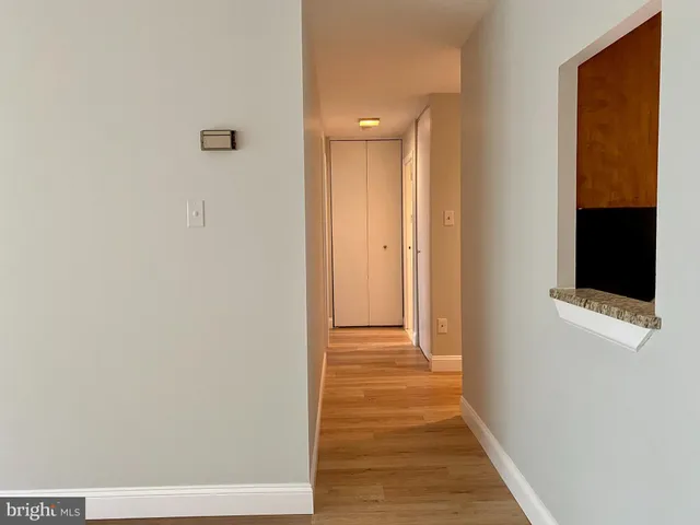 a view of a hallway with wooden floor