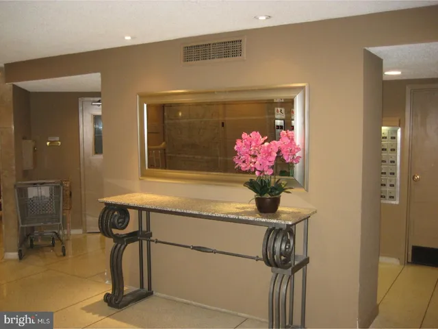 a bath room with a table and a vase