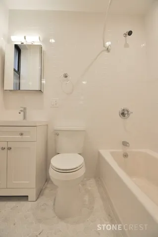 a bathroom with a toilet a sink a mirror and bathtub