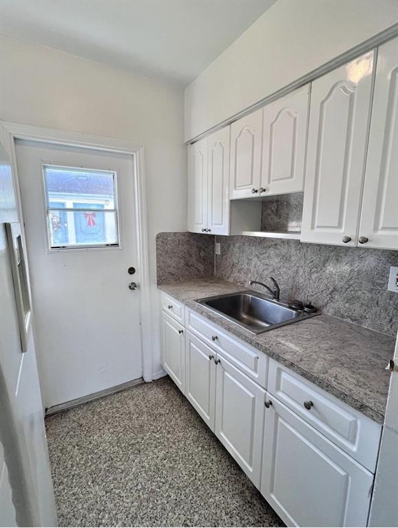 1120 Sesame Street, Unit 3 Opa-Locka, FL 33054 - Photo 3 of 6 a kitchen with granite countertop white cabinets and sink
