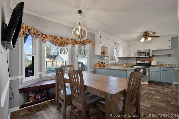 a view of a dining room with furniture a chandelier and wooden floor