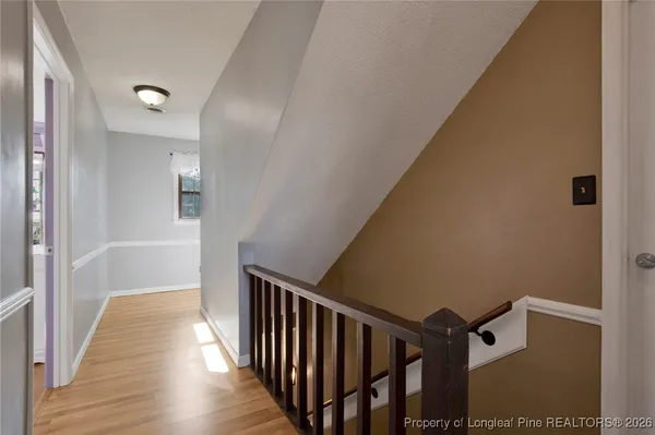 a view of a hallway with wooden floor and staircase