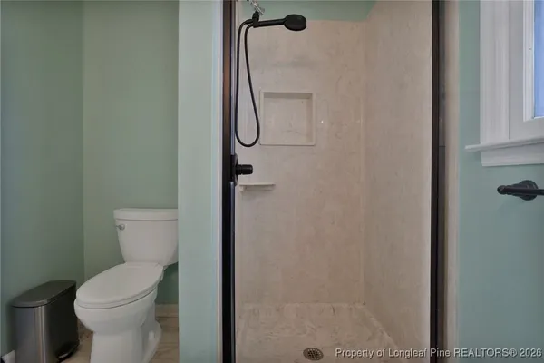 a living room with furniture a flat screen tv and a floor to ceiling window