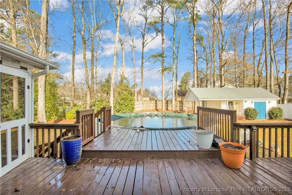 a view of a rooftop deck with chairs and wooden floor