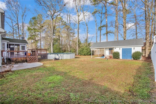 a view of a house with a yard covered with snow and trees
