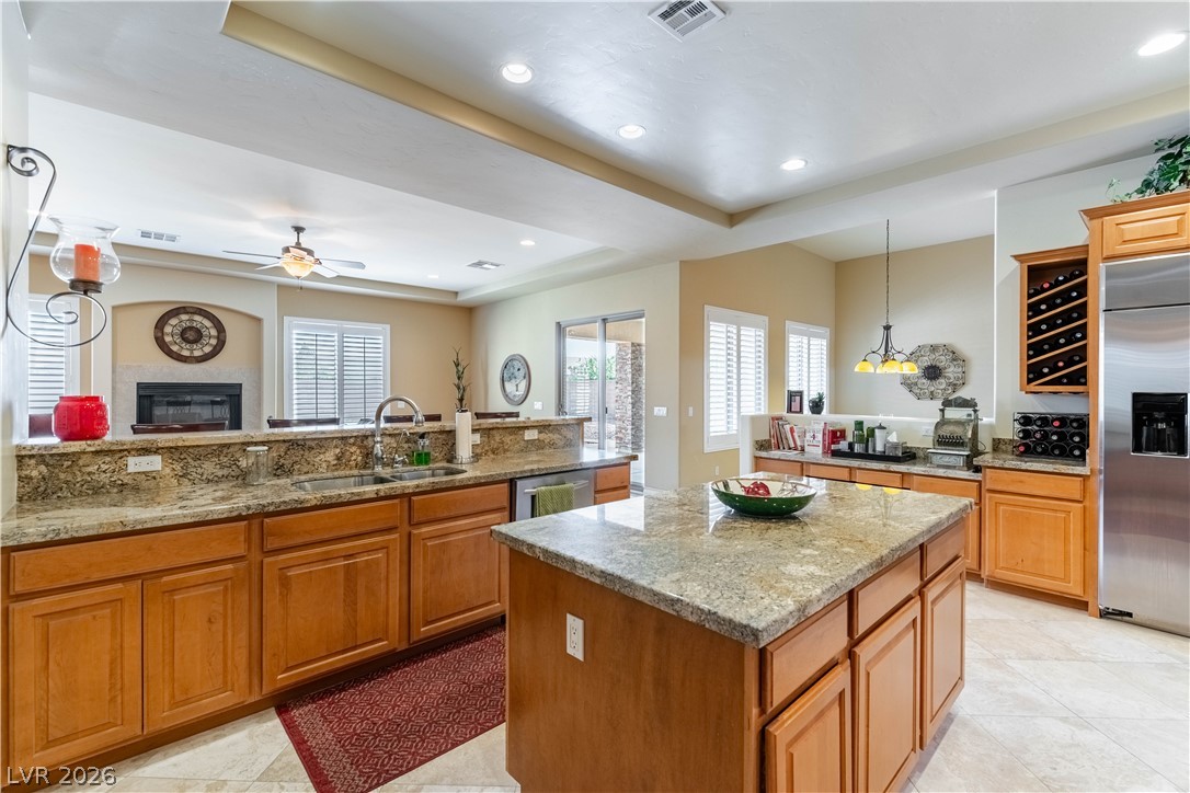 3661 Riley Ann Avenue Las Vegas, NV 89139 - Photo 16 of 42 An inviting kitchen with a granite island, a built-in wine rack, and a view into the living space.
