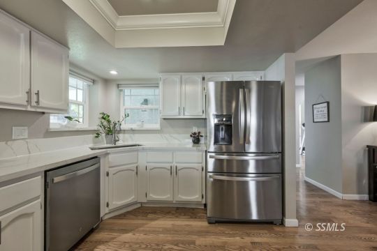 1113 Amie Court Ridgecrest, CA 93555 - Photo 6 of 33 a kitchen with stainless steel appliances granite countertop a refrigerator a sink a stove and white cabinets