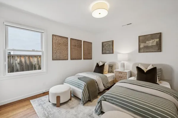 a bedroom with two beds and painting on the wall