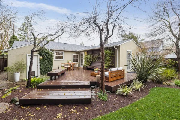 a view of a house with backyard water fountain and sitting area