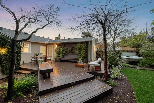 a view of a wooden chairs and table in the patio