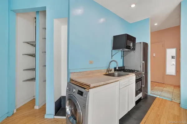 a view of a kitchen with a sink and a refrigerator