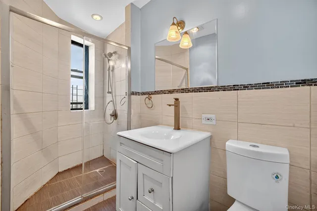 a bathroom with a granite countertop sink a toilet and mirror