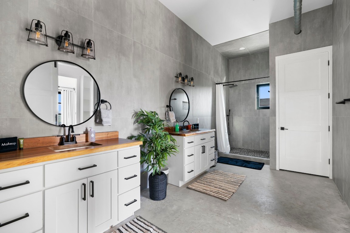 12701 Trails End Road Leander, TX 78641 - Photo 16 of 18 Primary bathroom featuring dual vanities, walk-in shower, concrete floors and modern fixtures.