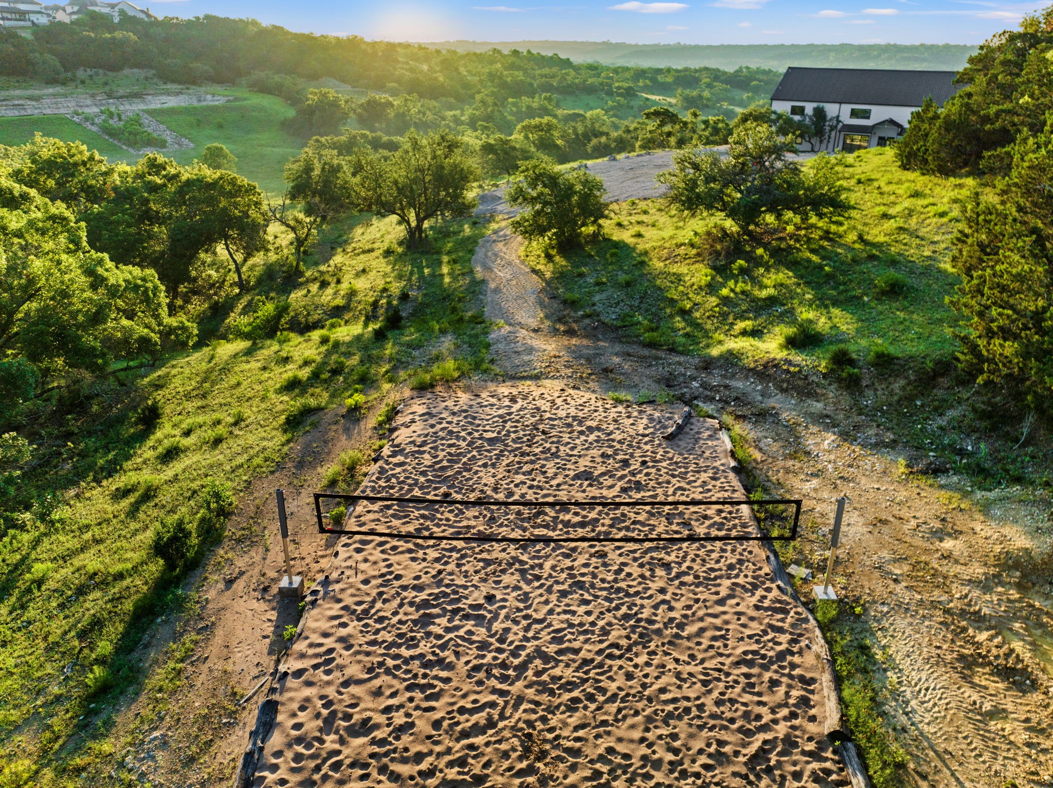12701 Trails End Road Cedar Park, TX 78613 - Photo 17 of 18 Volleyball Sand Court - Sand volleyball court located on the property with surrounding Hill Country terrain and trail access.