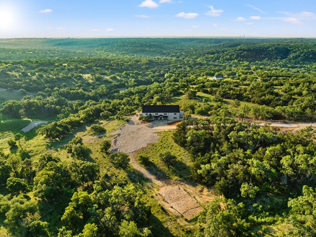 12701 Trails End Road Leander, TX 78641 - Photo 2 of 18 Wide aerial view showing the main residence, sand volleyball court, drive access and surrounding Hill Country terrain.