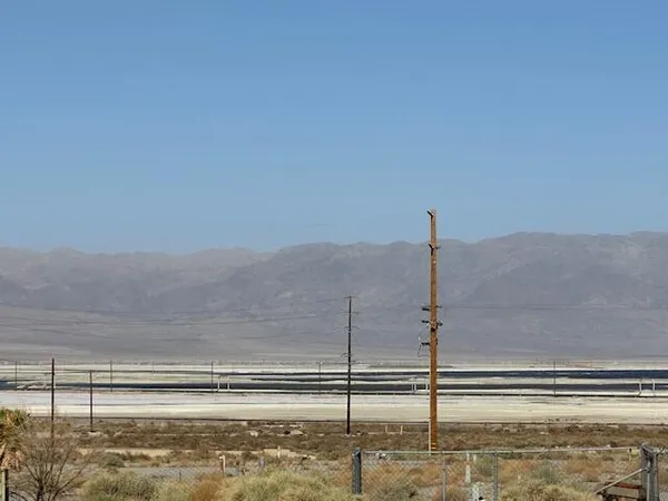 a view of a dry yard with wooden fence