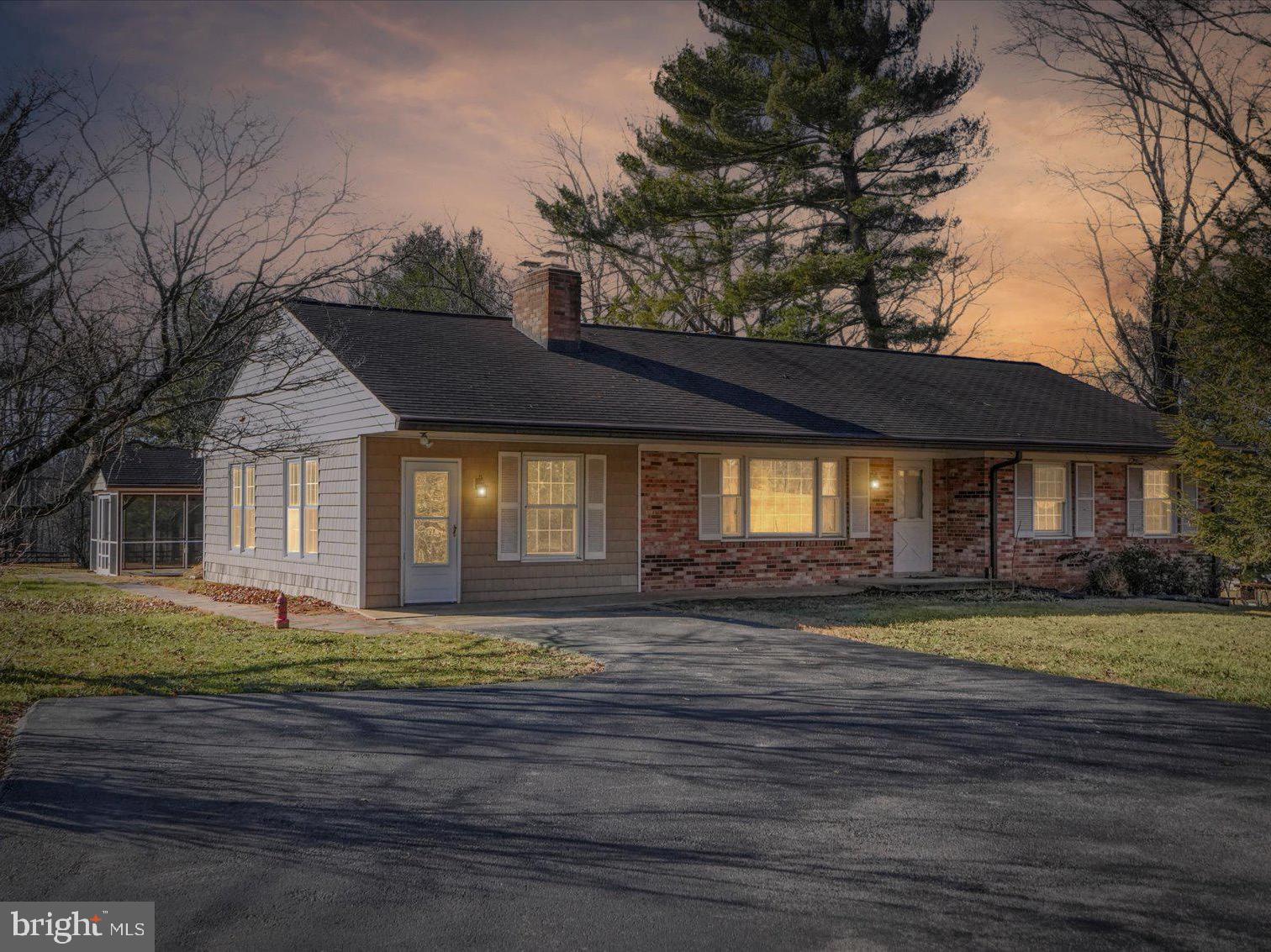 a view of a house with a big yard and large tree