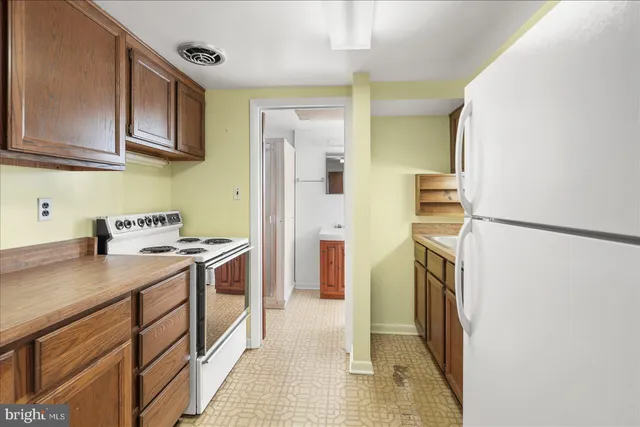 a kitchen with a sink a refrigerator and cabinets