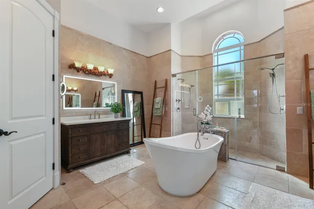a bathroom with a tub sink shower and mirror