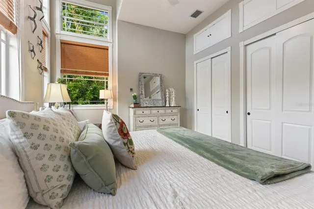 a bedroom with a bed and a flat tv screen on dresser