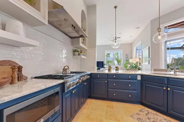 a kitchen with stainless steel appliances kitchen island granite countertop a refrigerator and microwave