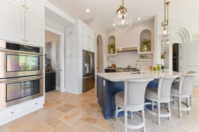 a living room with furniture flowerpot and a chandelier