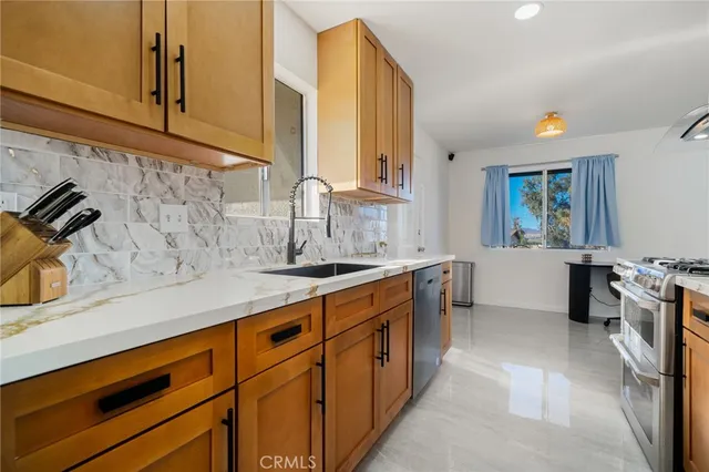 a kitchen with stainless steel appliances a sink stove and cabinets