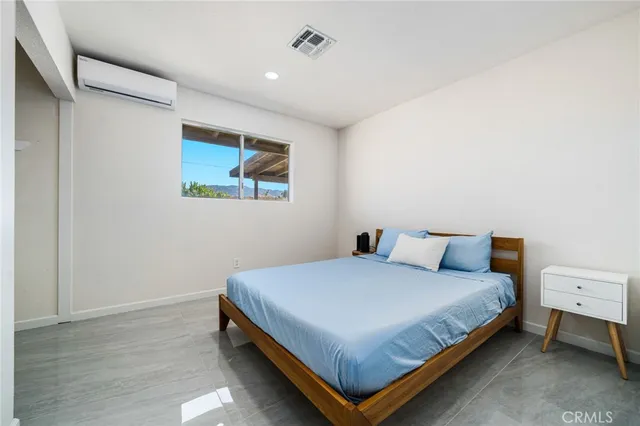 a bedroom with a bed and a wall painting